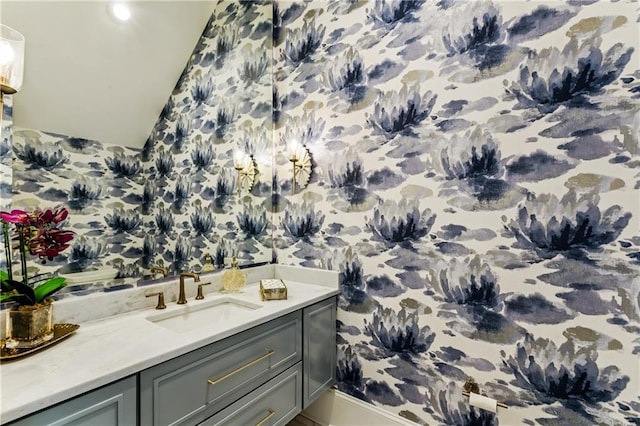 1617 Homer St, Metairie, LA 70005 - bathroom featuring lofted ceiling, vanity, baseboards, and wallpapered walls