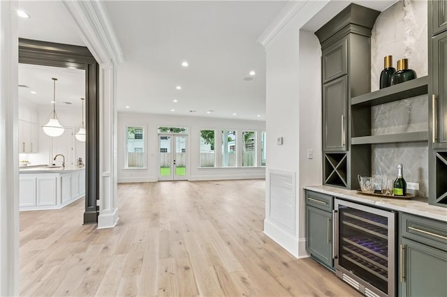 1617 Homer St, Metairie, LA 70005 - indoor dry bar with beverage cooler, ornamental molding, tasteful backsplash, light wood-type flooring, and recessed lighting