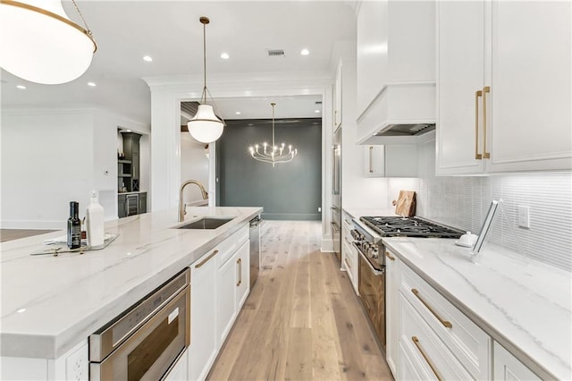 1617 Homer St, Metairie, LA 70005 - kitchen featuring a sink, custom exhaust hood, appliances with stainless steel finishes, white cabinets, and a large island with sink