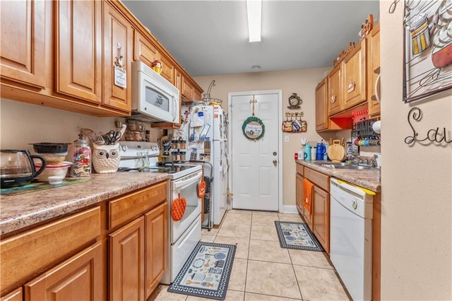 9101-9103 Atreus St, Chalmette, LA 70043 - kitchen featuring white appliances, light tile patterned floors, brown cabinets, and a sink