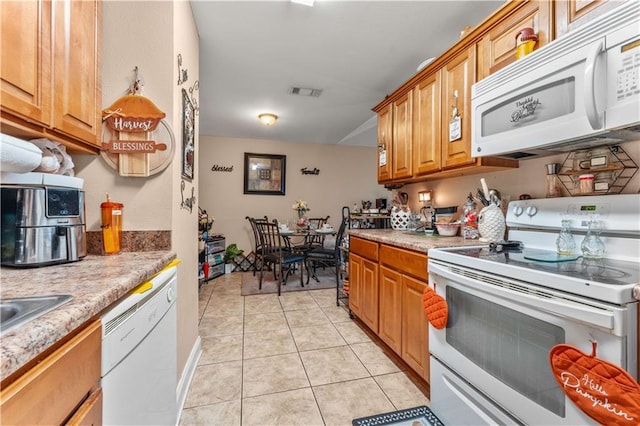9101-9103 Atreus St, Chalmette, LA 70043 - kitchen with white appliances, brown cabinets, light tile patterned floors, and light countertops