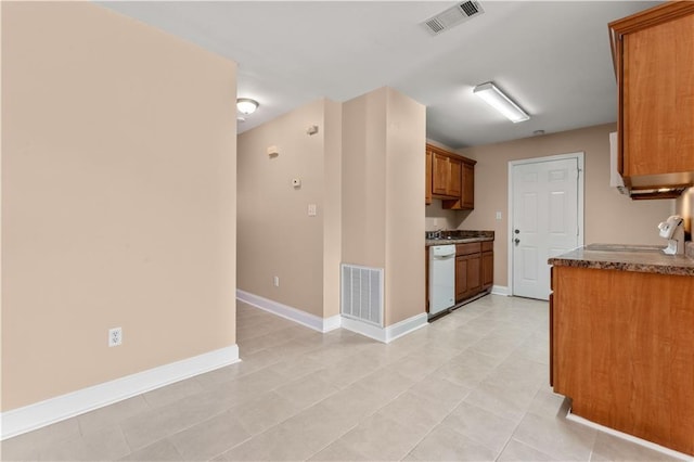9101-9103 Atreus St, Chalmette, LA 70043 - kitchen featuring brown cabinets, white dishwasher, baseboards, light tile patterned flooring, and dark stone countertops