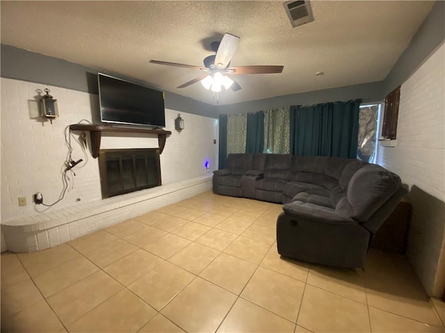 10116 16th Hwy, Amite, LA 70422 - living area featuring a glass covered fireplace, light tile patterned floors, a textured ceiling, and a ceiling fan