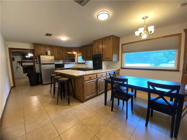 10116 16th Hwy, Amite, LA 70422 - kitchen featuring freestanding refrigerator, oven, a chandelier, a sink, and light countertops