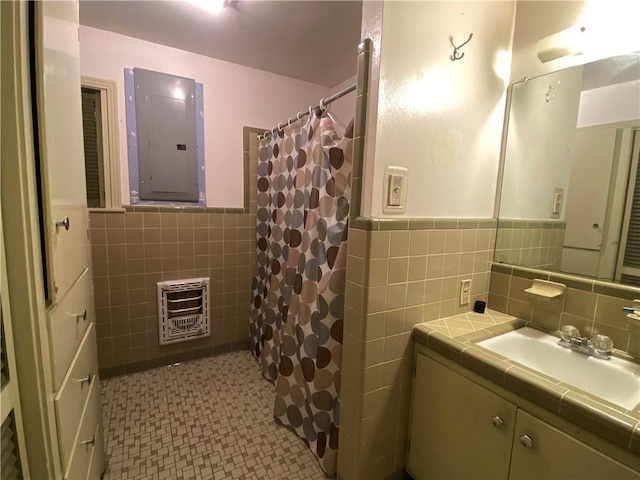 10116 16th Hwy, Amite, LA 70422 - full bathroom with electric panel, heating unit, tile walls, vanity, and a wainscoted wall