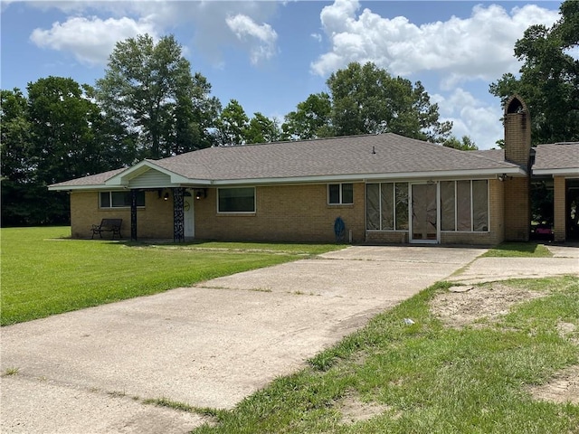 10116 16th Hwy, Amite, LA 70422 - view of front of home with concrete driveway, a front yard, brick siding, a chimney, and a shingled roof