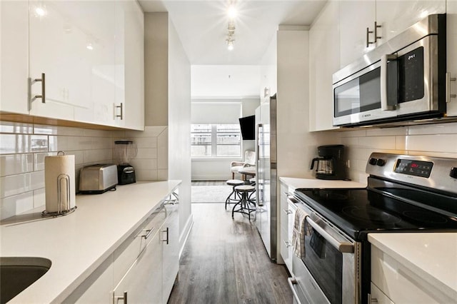 1111 Tulane Ave Unit 704, New Orleans, LA 70112 - kitchen featuring stainless steel appliances, dark wood-style flooring, white cabinets, light countertops, and backsplash