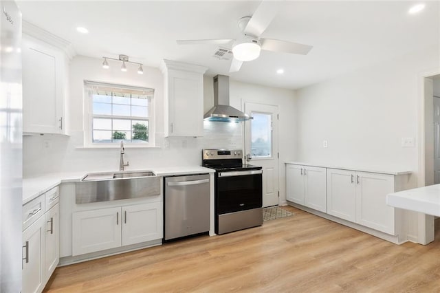2320 Roosevelt Blvd, Kenner, LA 70062 - kitchen with appliances with stainless steel finishes, wall chimney range hood, a sink, white cabinets, and recessed lighting