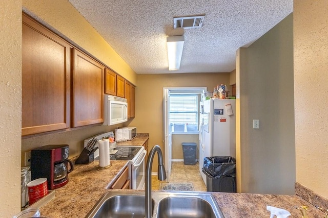 2425 Oxford Pl Unit 139, Gretna, LA 70056 - kitchen with white appliances, brown cabinetry, a sink, a textured ceiling, and light countertops
