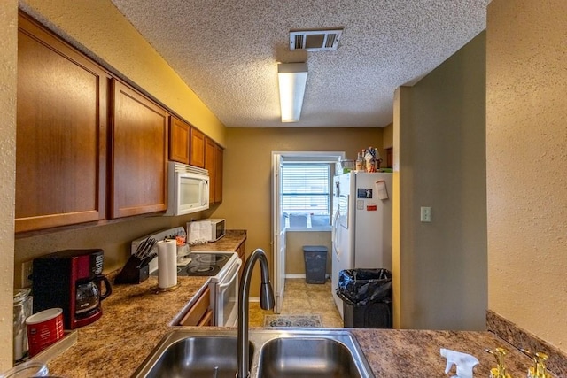 2425 Oxford Pl Unit 139, Gretna, LA 70056 - kitchen featuring white appliances, a sink, brown cabinets, and a textured ceiling