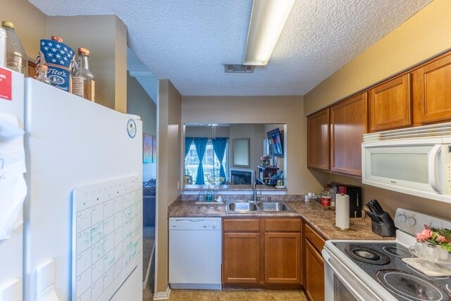 2425 Oxford Pl Unit 139, Gretna, LA 70056 - kitchen with white appliances, a sink, brown cabinetry, and a textured ceiling