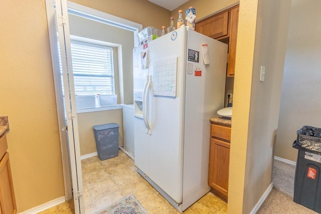 2425 Oxford Pl Unit 139, Gretna, LA 70056 - kitchen with white fridge with ice dispenser, brown cabinets, and baseboards