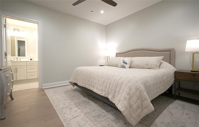 731 St Charles Ave Unit 305, New Orleans, LA 70130 - bedroom with light wood-style flooring, a sink, vaulted ceiling, baseboards, and connected bathroom