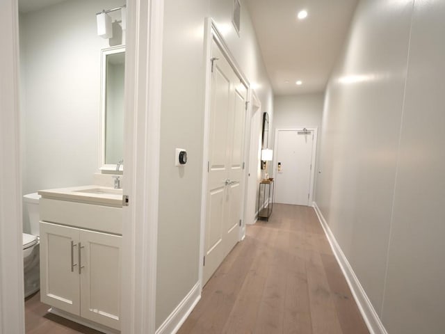 731 St Charles Ave Unit 305, New Orleans, LA 70130 - corridor featuring recessed lighting, light wood-type flooring, a sink, and baseboards