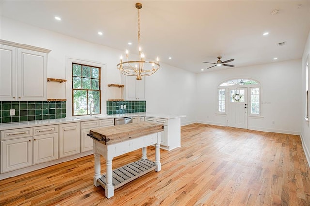 532 Elmira Ave, New Orleans, LA 70114 - kitchen featuring open shelves, light countertops, a peninsula, dishwasher, and healthy amount of natural light