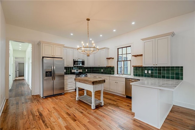 532 Elmira Ave, New Orleans, LA 70114 - kitchen with appliances with stainless steel finishes, a chandelier, a sink, a peninsula, and tasteful backsplash