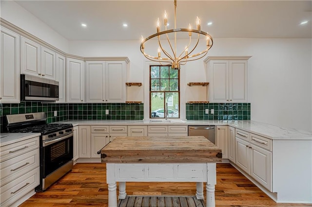 532 Elmira Ave, New Orleans, LA 70114 - kitchen with stainless steel appliances, a chandelier, open shelves, light wood-style flooring, and a sink