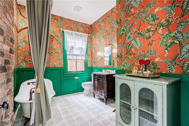 532 Elmira Ave, New Orleans, LA 70114 - bathroom featuring wallpapered walls, a wainscoted wall, vanity, and toilet