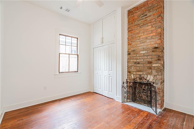 532 Elmira Ave, New Orleans, LA 70114 - unfurnished living room featuring light wood finished floors, baseboards, a large fireplace, and ceiling fan