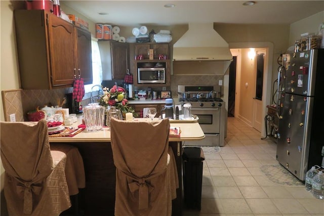 221513 James St, Jefferson, LA 70121 - kitchen featuring stainless steel appliances, ventilation hood, a peninsula, backsplash, and light countertops