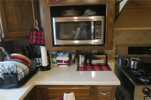 221513 James St, Jefferson, LA 70121 - kitchen view of stainless steel microwave, stove, light countertops, and decorative backsplash
