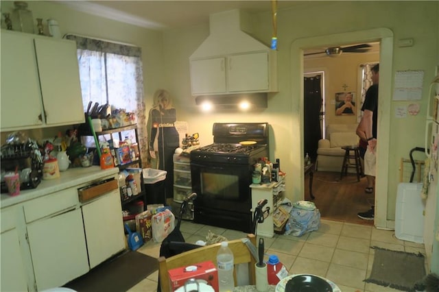 221513 James St, Jefferson, LA 70121 - kitchen featuring black gas stove, light countertops, light tile patterned floors, and white cabinetry