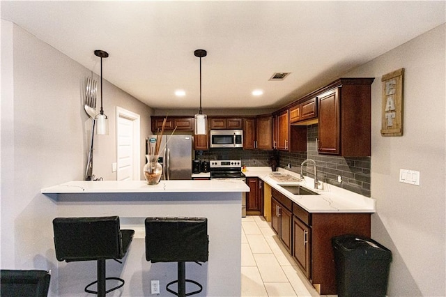 7510 Branch Dr, New Orleans, LA 70128 - kitchen with appliances with stainless steel finishes, a sink, backsplash, a peninsula, and light countertops