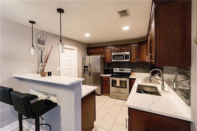 7510 Branch Dr, New Orleans, LA 70128 - kitchen with stainless steel appliances, a sink, a kitchen breakfast bar, tasteful backsplash, and a peninsula
