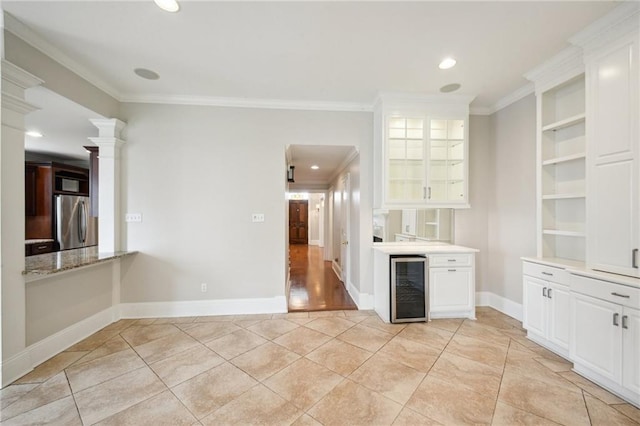 404 Atherton Dr, Metairie, LA 70005 - kitchen with freestanding refrigerator, wine cooler, ornamental molding, white cabinetry, and recessed lighting