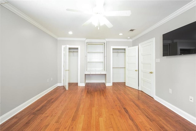 404 Atherton Dr, Metairie, LA 70005 - unfurnished bedroom featuring multiple closets, ornamental molding, baseboards, hardwood / wood-style flooring, and recessed lighting