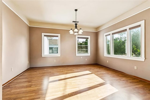 400 Aris Ave, Metairie, LA 70005 - spare room with a chandelier, wood finished floors, and baseboards