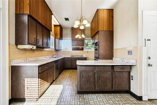 400 Aris Ave, Metairie, LA 70005 - kitchen with a chandelier, appliances with stainless steel finishes, light countertops, a peninsula, and a sink