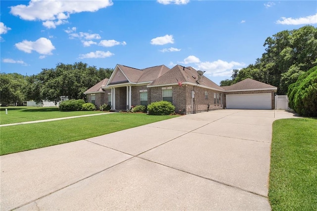 135 Maud Olive Dr, Belle Chasse, LA 70037 - view of front facade featuring a front yard, driveway, brick siding, and an attached garage