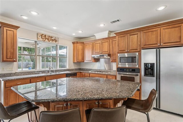436 Northpark Blvd, Covington, LA 70433 - kitchen with stainless steel appliances, brown cabinets, crown molding, a breakfast bar area, and recessed lighting