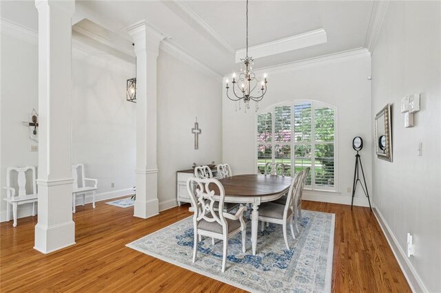 436 Northpark Blvd, Covington, LA 70433 - dining room with ornate columns, wood finished floors, crown molding, and a chandelier