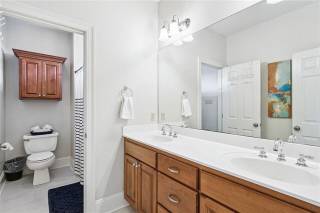 436 Northpark Blvd, Covington, LA 70433 - bathroom featuring double vanity, toilet, and baseboards