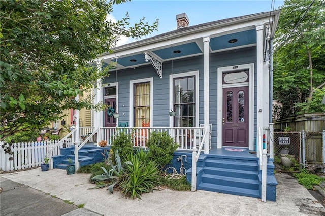 11315 Vallette St, New Orleans, LA 70114 - shotgun-style home featuring a chimney and a porch