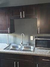 2543-45 Gravier St, New Orleans, LA 70119 - kitchen with a sink and dark brown cabinets