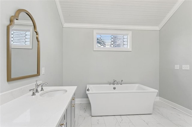 full bathroom featuring marble finish flooring, a freestanding bath, vanity, crown molding, and baseboards