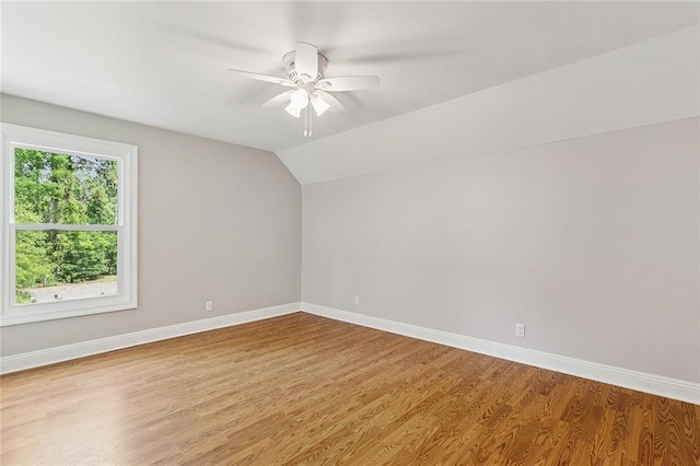 empty room featuring baseboards, a ceiling fan, wood finished floors, and lofted ceiling