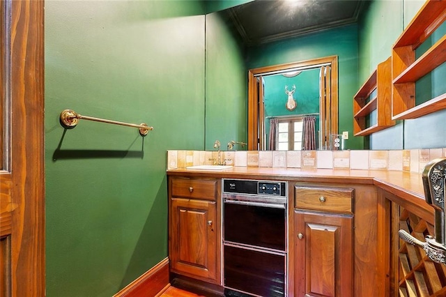 9816 Elm Pl, River Ridge, LA 70123 - kitchen featuring open shelves, a sink, ornamental molding, and brown cabinetry