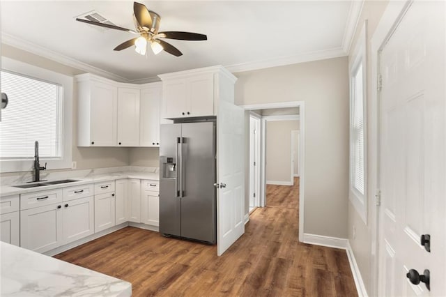 2718 Palmyra St, New Orleans, LA 70119 - kitchen with high end refrigerator, a sink, white cabinetry, crown molding, and wood finished floors