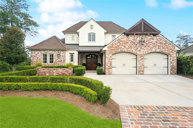 28 Wax Myrtle Ln, Covington, LA 70433 - french provincial home featuring brick siding, driveway, a standing seam roof, an attached garage, and roof with shingles