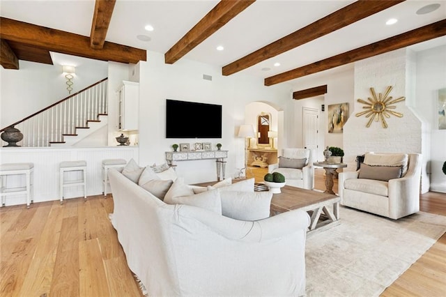 28 Wax Myrtle Ln, Covington, LA 70433 - living room featuring light wood finished floors, arched walkways, stairway, recessed lighting, and beam ceiling