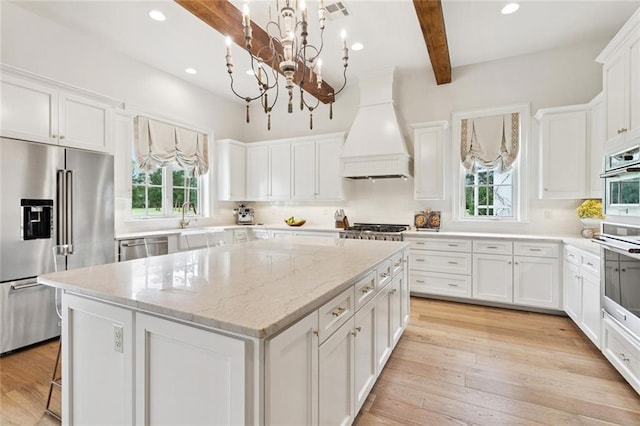 28 Wax Myrtle Ln, Covington, LA 70433 - kitchen with stainless steel appliances, premium range hood, healthy amount of natural light, a chandelier, and beam ceiling