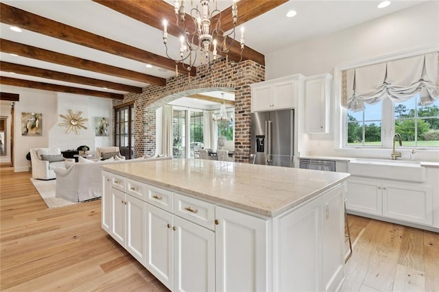 28 Wax Myrtle Ln, Covington, LA 70433 - kitchen with a chandelier, stainless steel appliances, beamed ceiling, a sink, and arched walkways