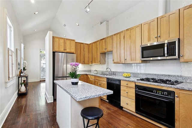 1208 Joseph St, New Orleans, LA 70115 - kitchen with black appliances, dark wood-type flooring, a sink, lofted ceiling, and decorative backsplash