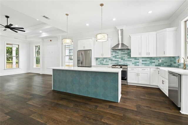 5516 Warrington Dr, New Orleans, LA 70122 - kitchen with stainless steel appliances, wall chimney range hood, a center island, light countertops, and a ceiling fan