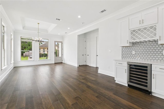 5516 Warrington Dr, New Orleans, LA 70122 - indoor dry bar featuring beverage cooler, a chandelier, dark wood-style flooring, decorative backsplash, and baseboards