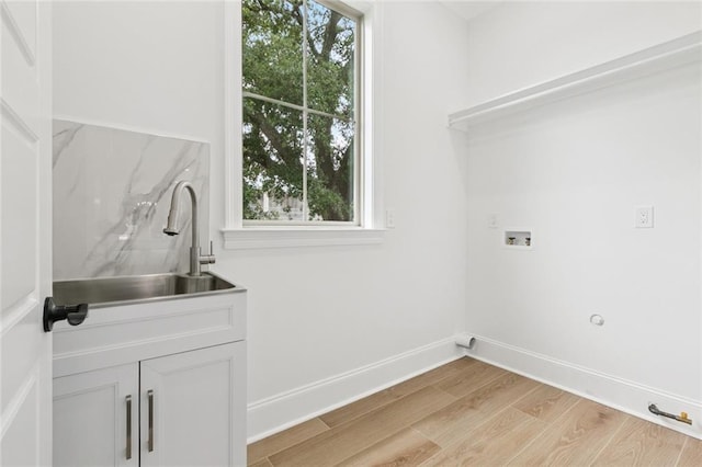 5516 Warrington Dr, New Orleans, LA 70122 - washroom with washer hookup, light wood-style floors, a sink, and baseboards